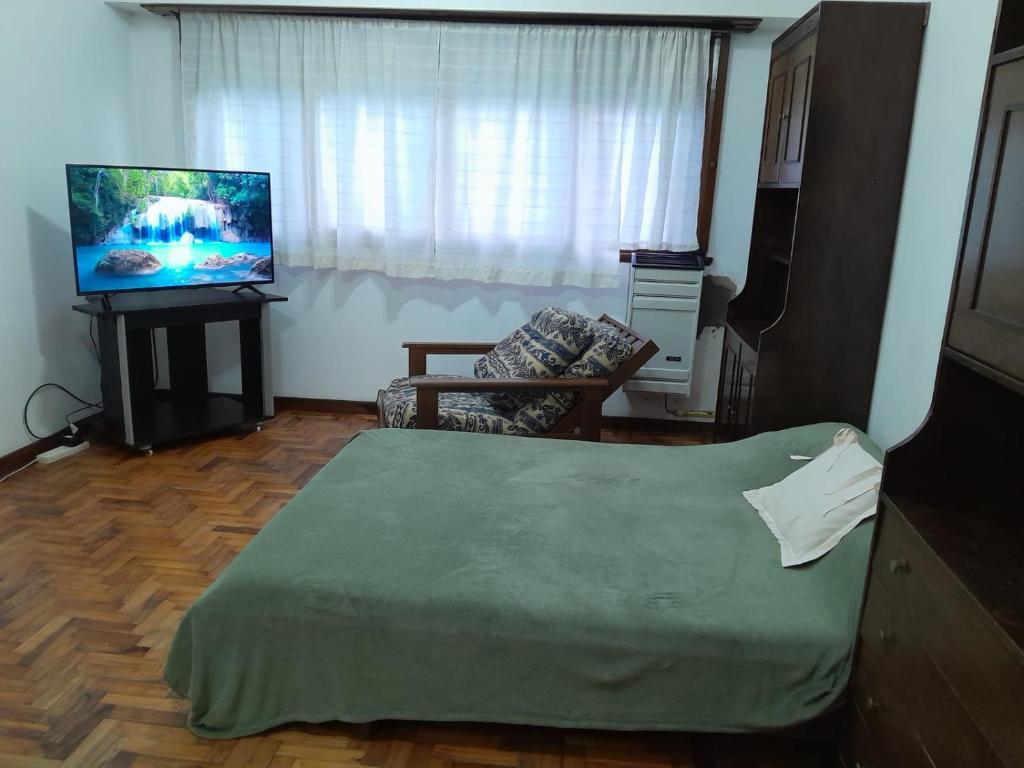 un soggiorno con letto e TV a schermo piatto di Depto 1 amb Av Colon a Mar del Plata