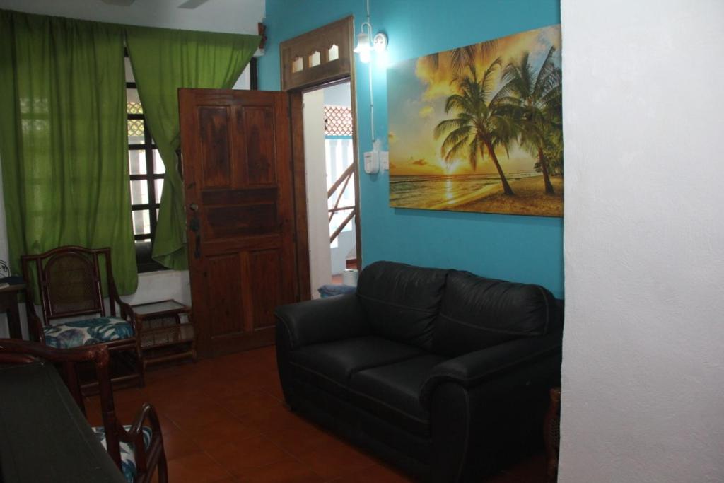 a living room with a couch and a painting on the wall at Malecon Beach House in Progreso 1 block from beach in Progreso