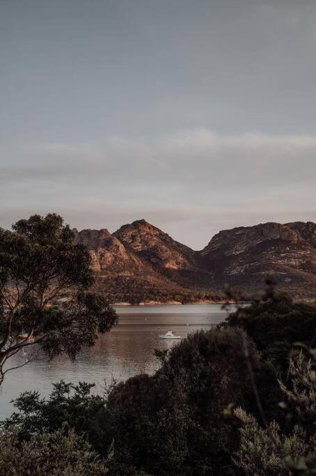 a view of a lake with mountains in the background at Sentinel at Freycinet in Coles Bay