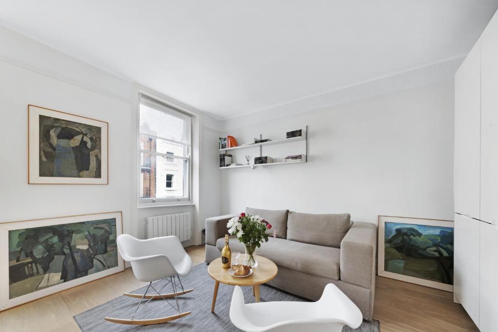 a living room with a couch and a table and chairs at Crawford Street Apartment By Morethanstays in London