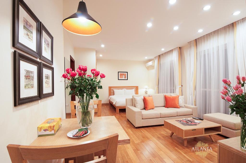 a living room with a couch and a table with flowers at Atlanta Residences in Hanoi