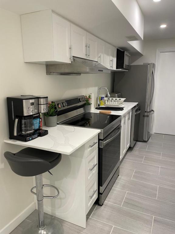 eine Küche mit weißen Schränken und einer weißen Arbeitsplatte in der Unterkunft New Cosy bright and Spacious Apartment in East Gwillimbury