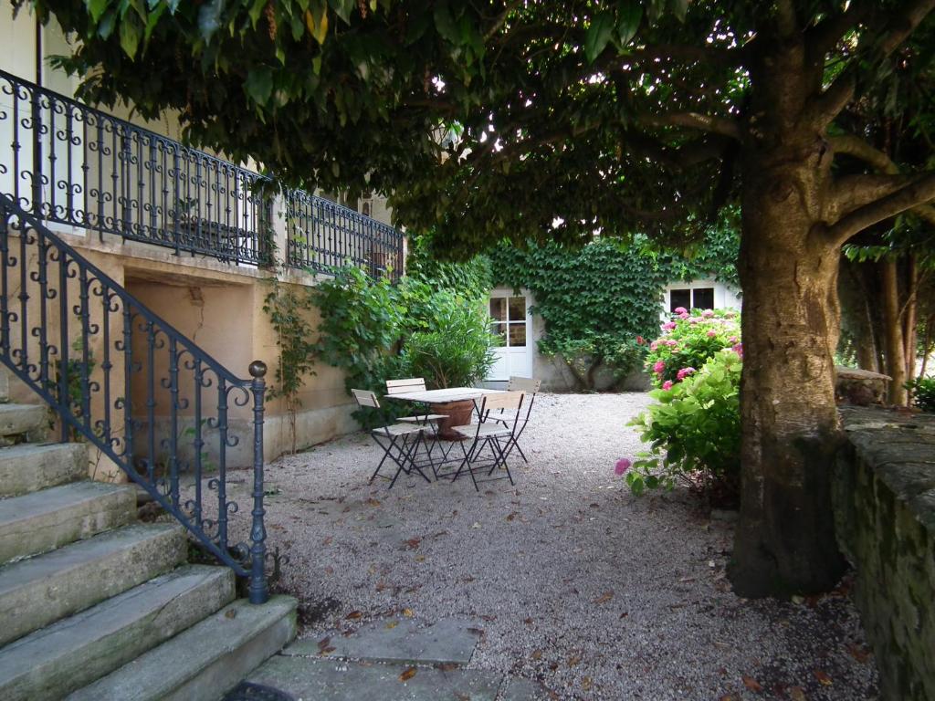 a garden with a table and chairs and a tree at B&B Au Pain Quotidien in Barizey