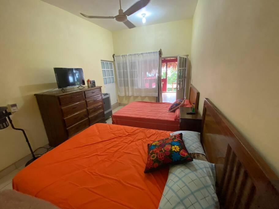 ein Schlafzimmer mit einem orangenen Bett und einer Kommode in der Unterkunft Departamento 4 personas Xela in San Pedro Pochutla