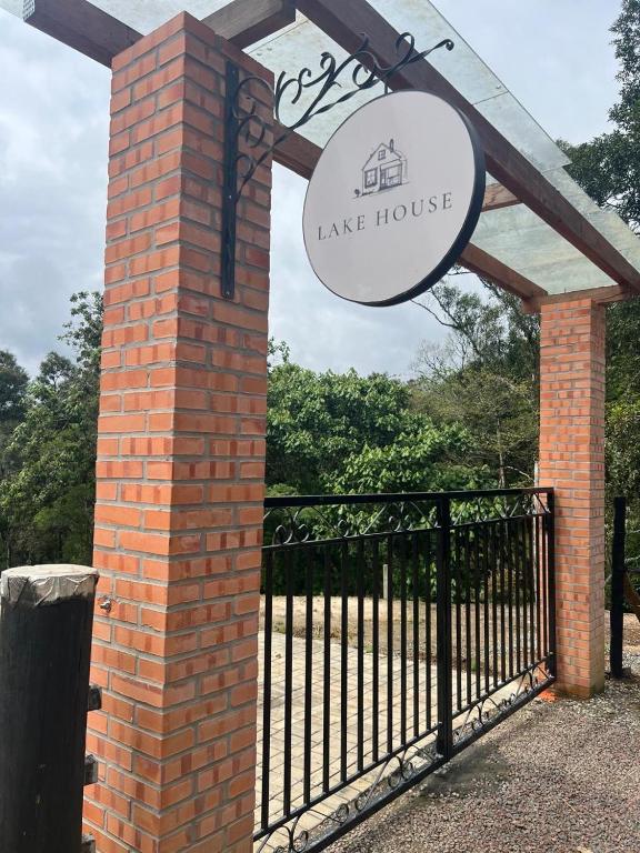 a sign for a lake house in front of a gate at Lake House_SC in Rio Forcação