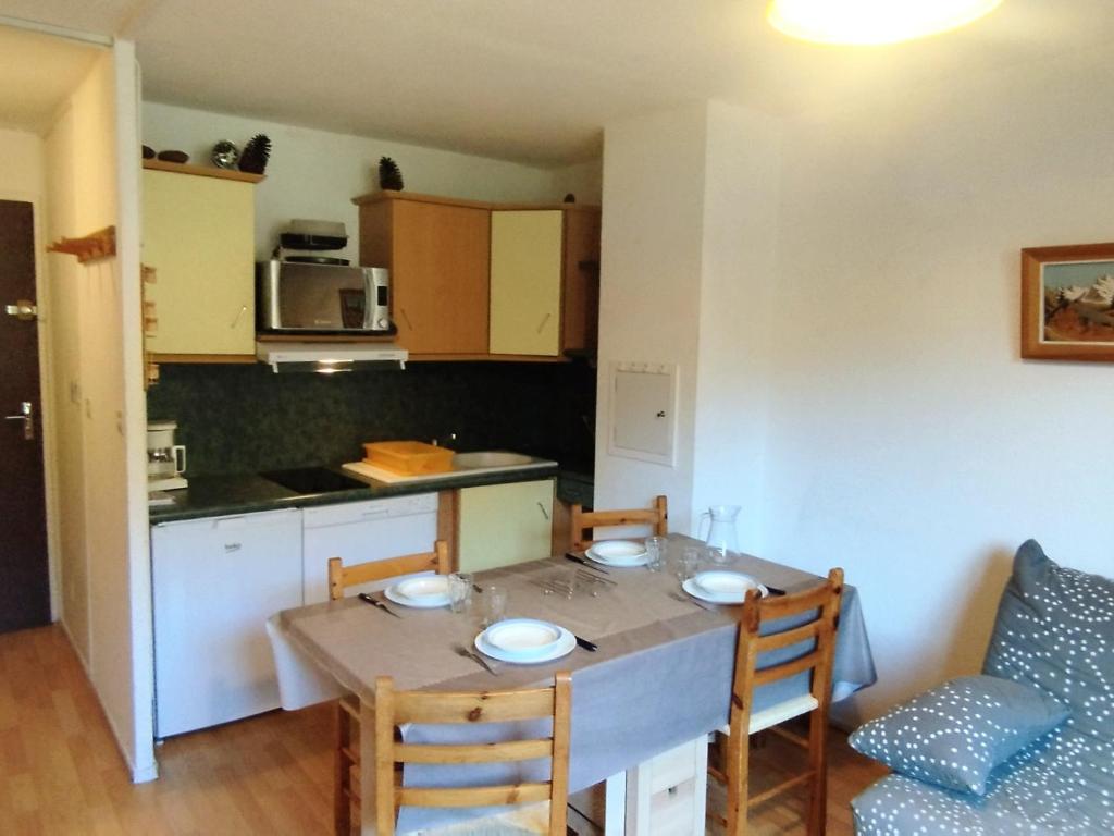 une cuisine avec une table et des chaises dans une pièce dans l'établissement Appartement 2 Pièces aux Pieds des Pistes, Terrasse, Proche Remontées - FR-1-771-53, à Les Adrets