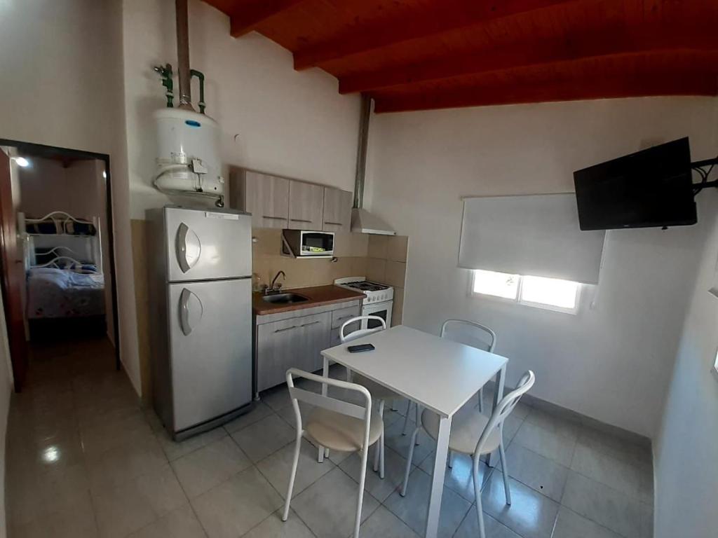 a kitchen with a table and a white refrigerator at Gotas de Rocio in San Antonio Oeste