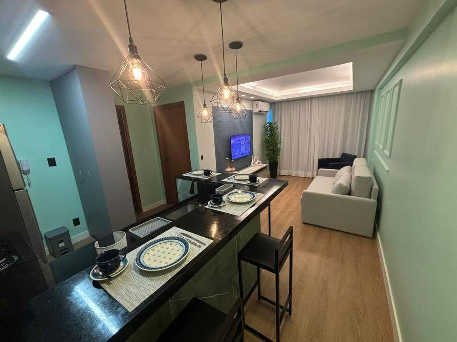 a kitchen and living room with a table and chairs at Flat Rosarinho - Confortável e Super Completo in Recife