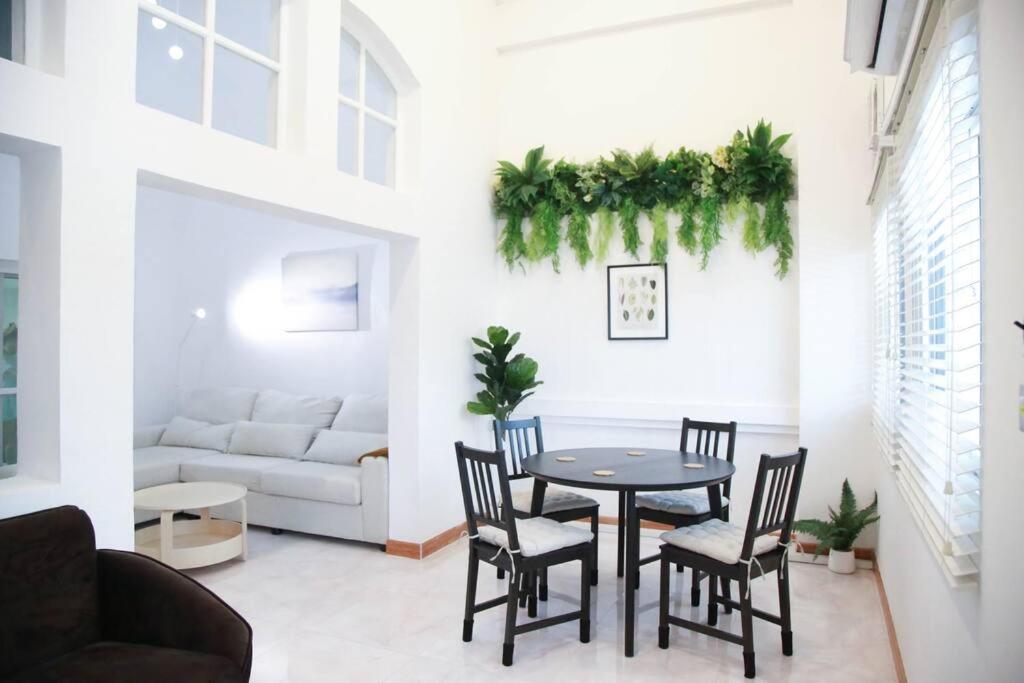 ein Wohnzimmer mit Tisch und Stühlen und einer Couch in der Unterkunft Near BTS Bearing Skytrain- Homey living Townhome - 4 Bedrooms in Bangkok