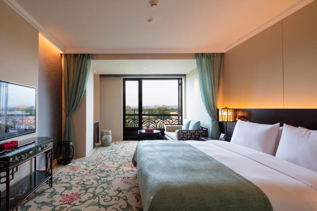 a hotel room with a large bed and a television at Grand Hotel Beijing Forbidden City in Beijing