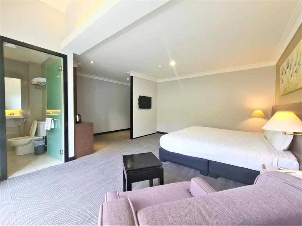 Postel nebo postele na pokoji v ubytování Merdeka Hotel Kluang