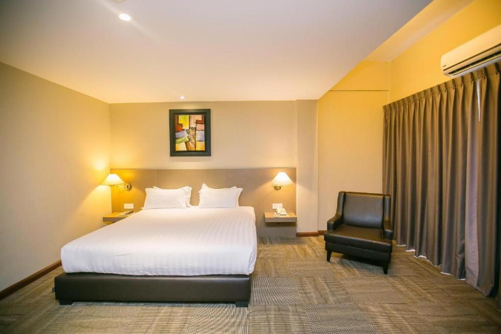 Postel nebo postele na pokoji v ubytování Merdeka Hotel Kluang