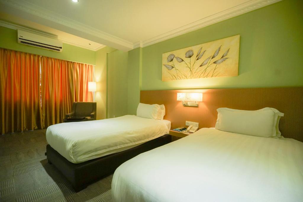Postel nebo postele na pokoji v ubytování Merdeka Hotel Kluang