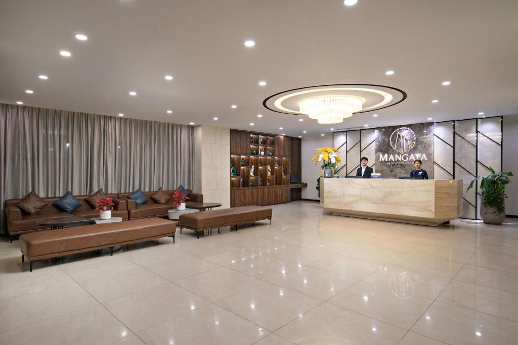 A polished reception lobby with staffed check-in and a long sofa seating area.