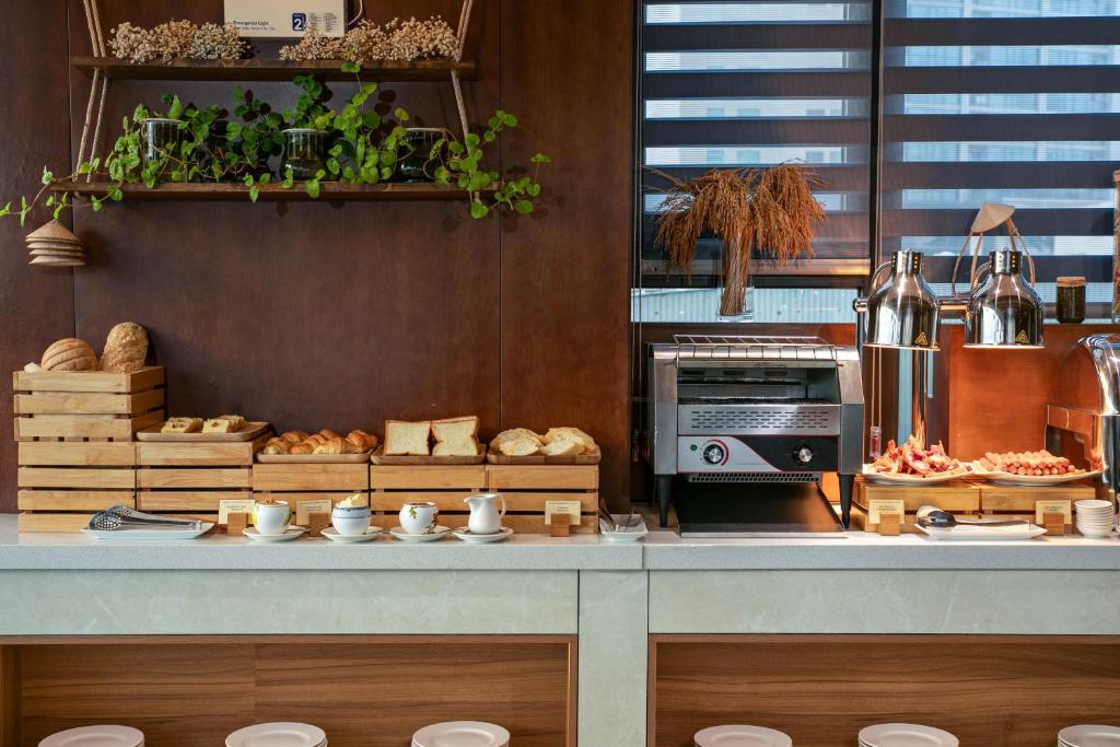 A bakery-style breakfast counter with breads, pastries and hot drinks.