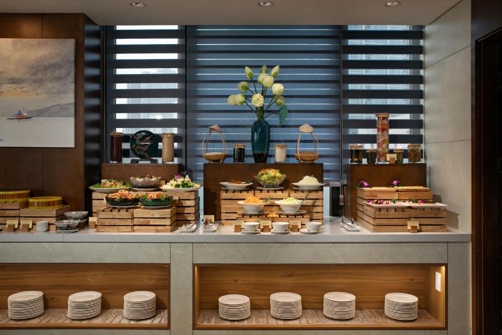 A compact buffet display with prepared dishes, bowls and stacked plates.