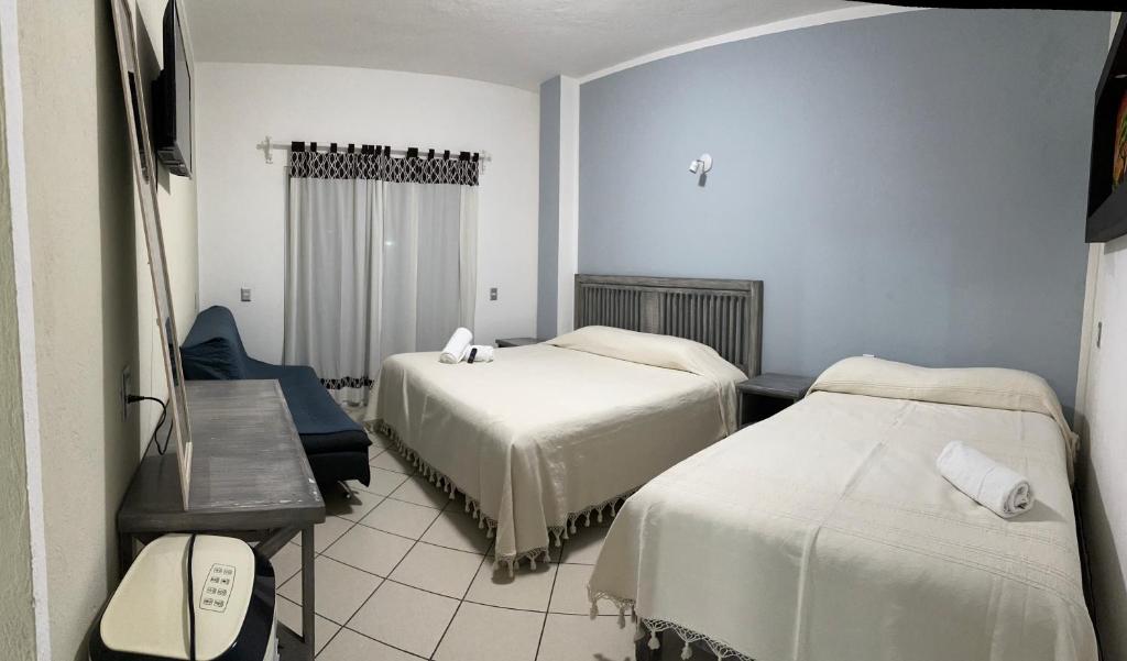 una camera con due letti e un tavolo e una sedia di Casa Eva a Tepoztlán