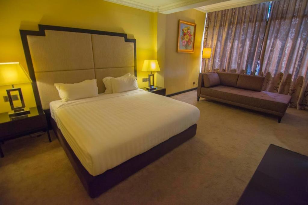 Postel nebo postele na pokoji v ubytování Merdeka Hotel Kluang