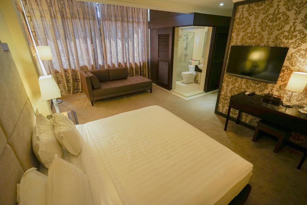 Postel nebo postele na pokoji v ubytování Merdeka Hotel Kluang