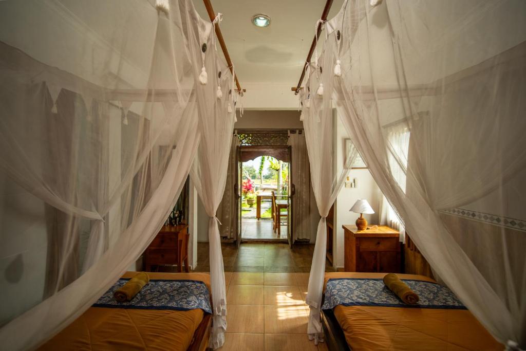Postel nebo postele na pokoji v ubytování Kubu Sari Ubud