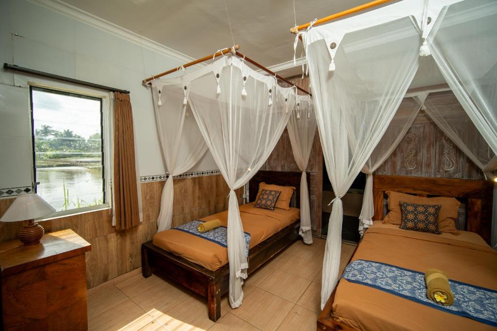 Postel nebo postele na pokoji v ubytování Kubu Sari Ubud