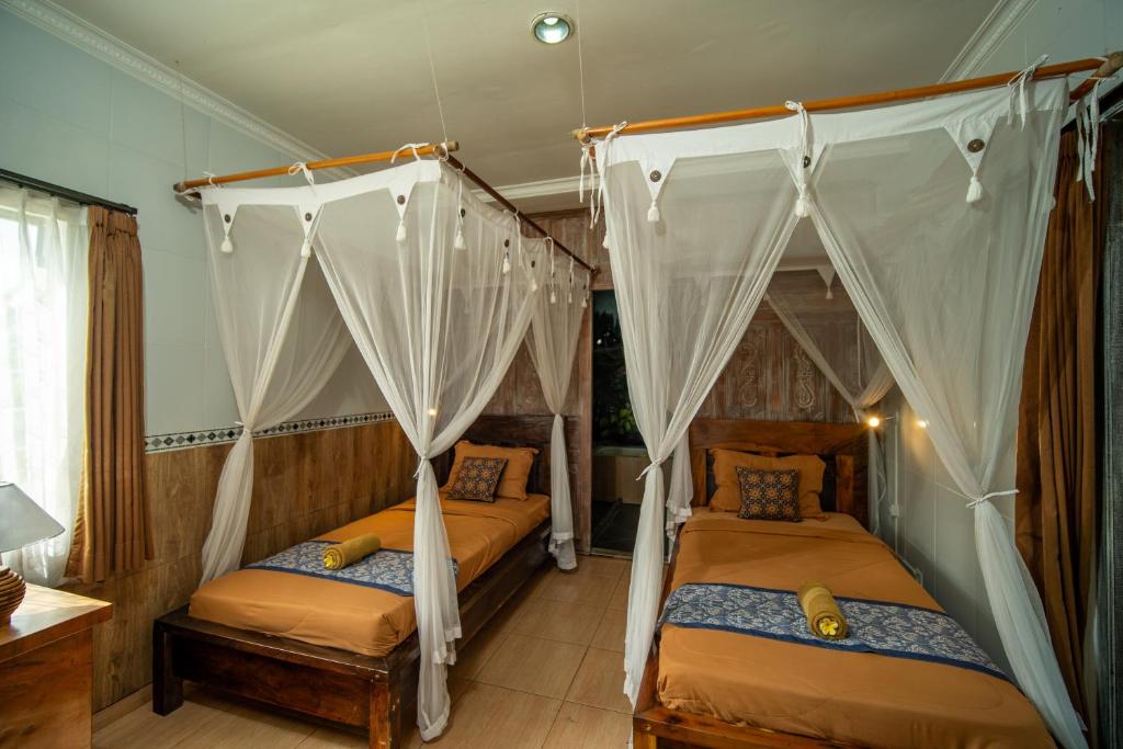 Postel nebo postele na pokoji v ubytování Kubu Sari Ubud