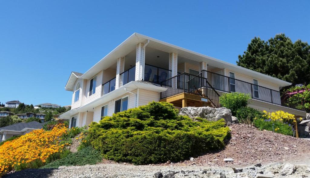 a large white house on top of a hill at Peachland Lake View Spectacular! in Peachland