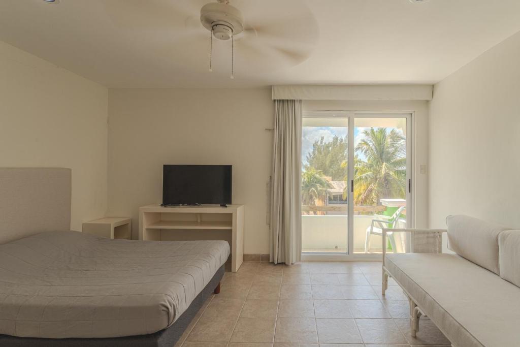 a bedroom with a bed and a tv and a couch at Playa Turix Villa in Chicxulub