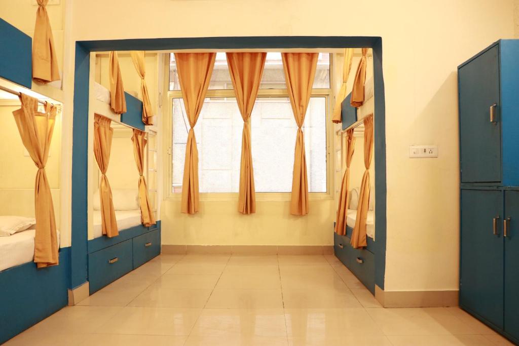 una camera con porte blu e una finestra di Shiv Shakti Hostel a Rishikesh