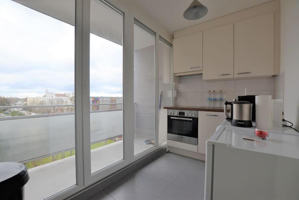 a kitchen with white appliances and a large window at Studio 76 - Balcon, proche Bâle in Saint-Louis