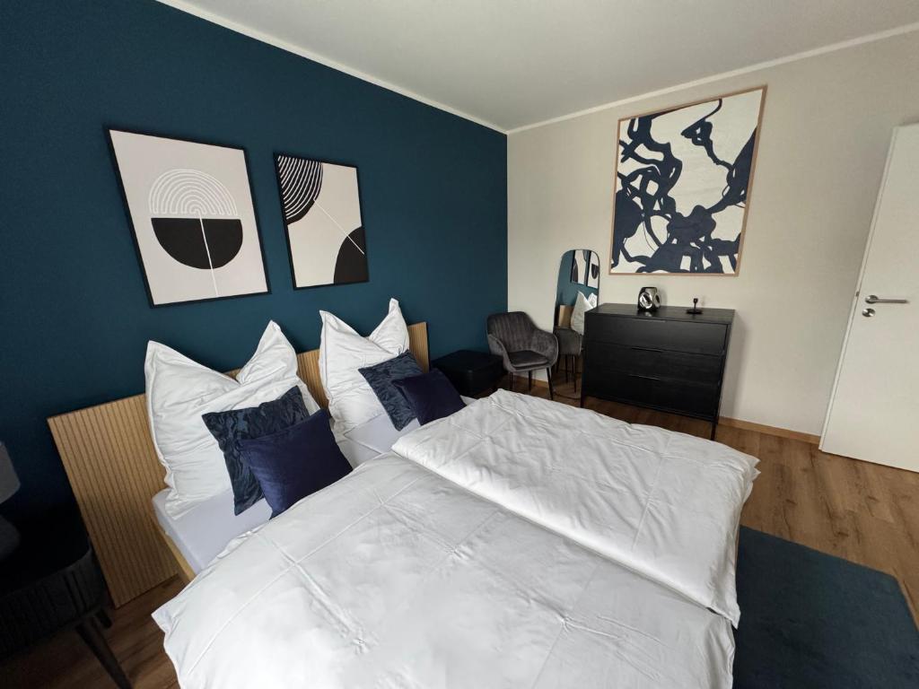 a bedroom with a white bed with blue walls at Sankt Göres Suites in Düsseldorf