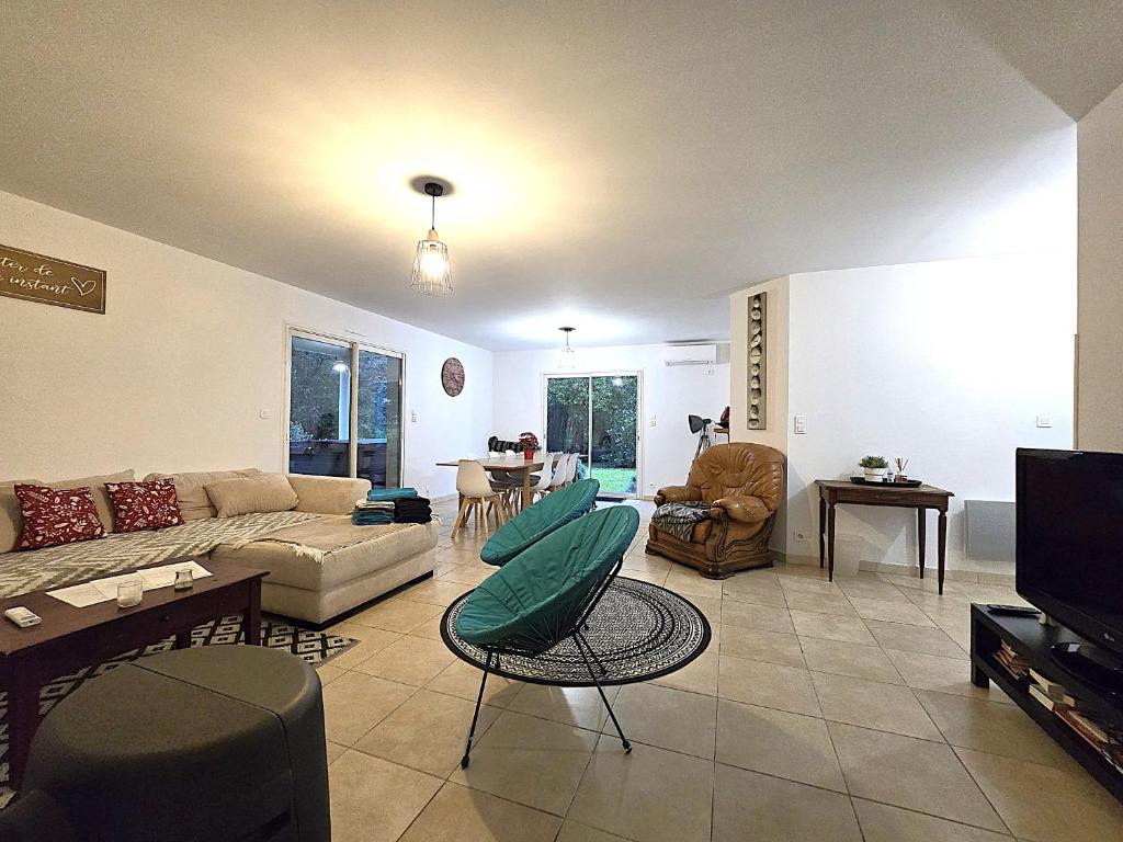 un soggiorno con un divano e una TV di Le Parc Jean Édouard - Spa avec jacuzzi privé - Superbe villa 4 chambres - 9 couchages - 6 lits - Poêle - Parking - Climatisation réversible- Terrasse ombragée et grand jardin a Montech