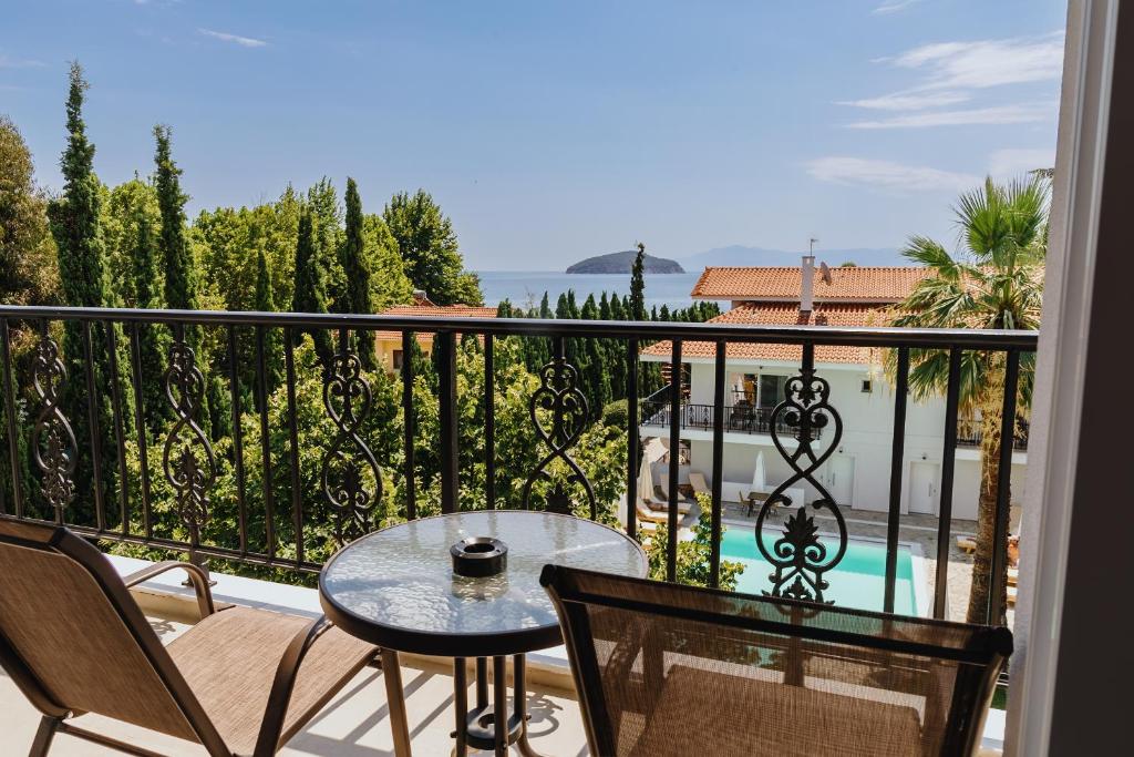 a balcony with a table and chairs and a view at Blue Bay Hotel in Iraklitsa