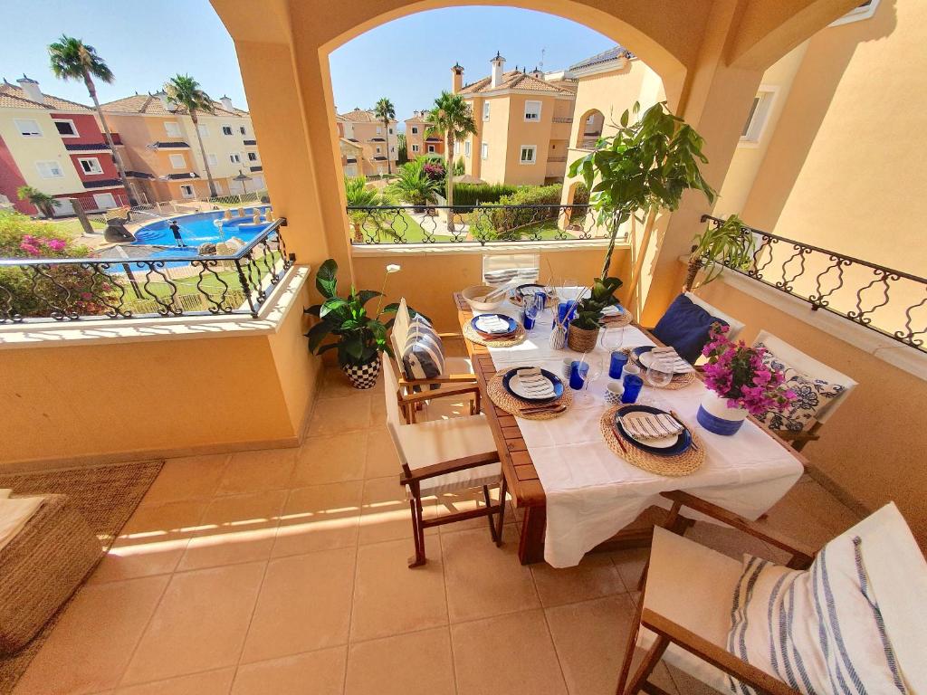 a table and chairs on a balcony with a view of a pool at Dúplex Águeda Altaona Golf in Murcia