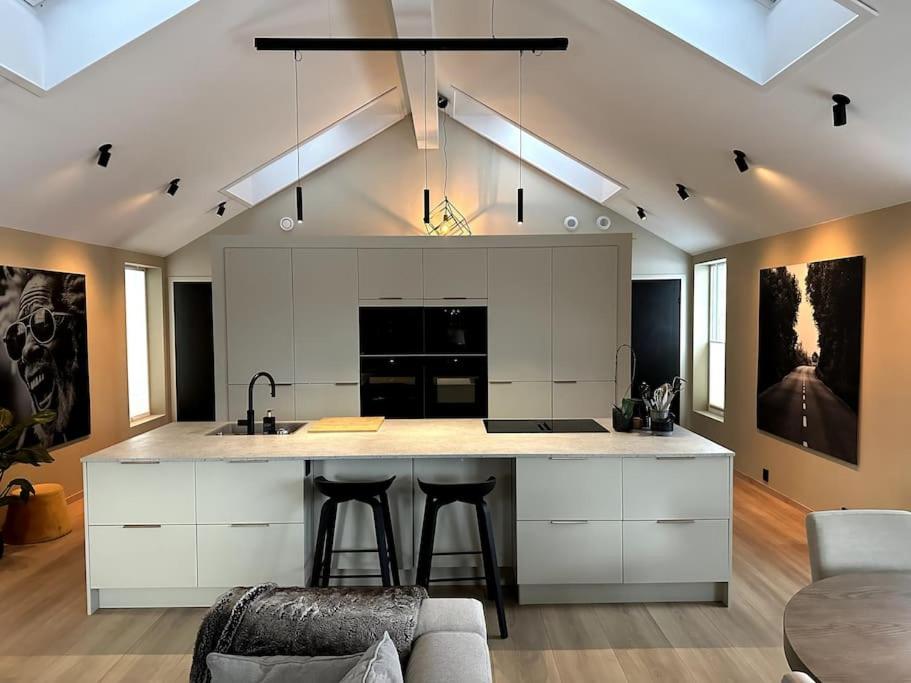 a kitchen with a large island with bar stools at Enebolig Trondheim, familievennlig, nytt 2023 in Trondheim
