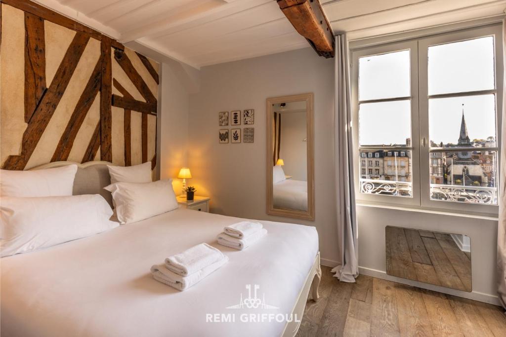 une chambre avec un lit blanc avec une grande fenêtre dans l'établissement Dolphin view - 1st floor - Charming comfortable flat on the port, à Honfleur