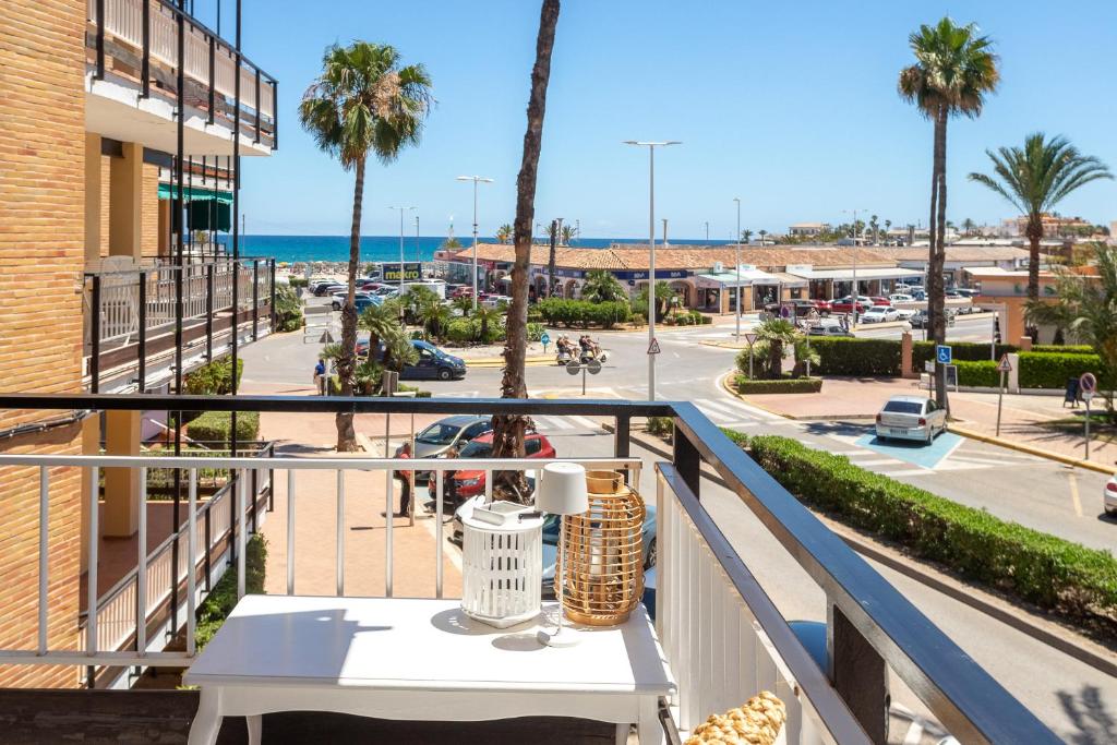a table on a balcony with a view of a street at Luxe 6 pers strand app met zeezicht en zwembad Arenal Beach in Platja de l'Arenal