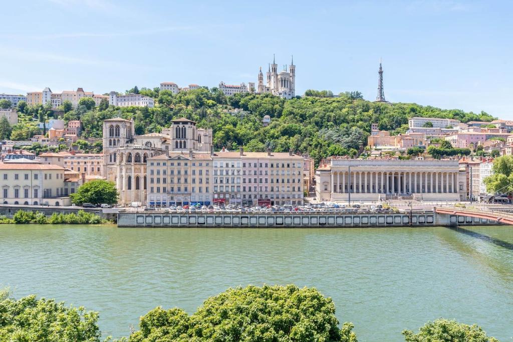 une ville avec un pont sur une masse d'eau dans l'établissement Panorama - Magnificent flat with breathtaking view of Fourvière Basilica, à Lyon