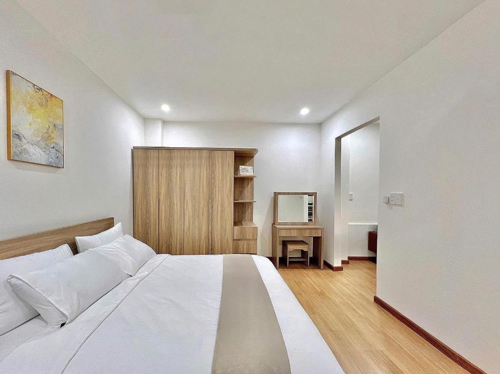 a bedroom with a large white bed and a desk at Cozy Home Airport - Self check-in 247 in Ho Chi Minh City