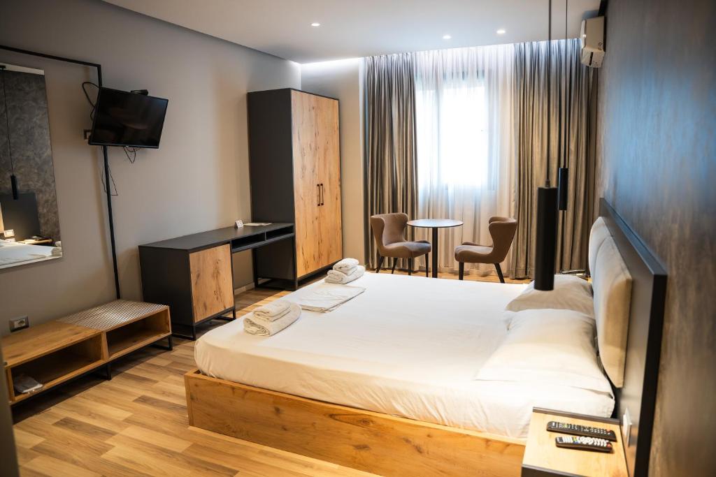 a bedroom with a bed and a desk and chairs at Center Boutique Hotel in Tirana