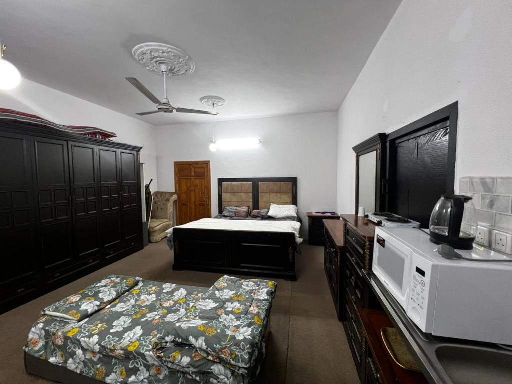 a bedroom with a bed and a microwave at استديو بمدخل خاص 7 دقائق للحرم in Sulţānah