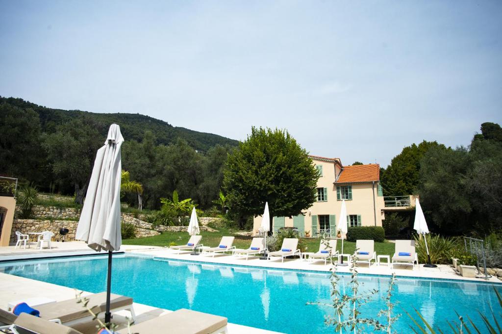 - une piscine avec des chaises et des parasols à côté d'un bâtiment dans l'établissement Grasse Mongibello, à Grasse