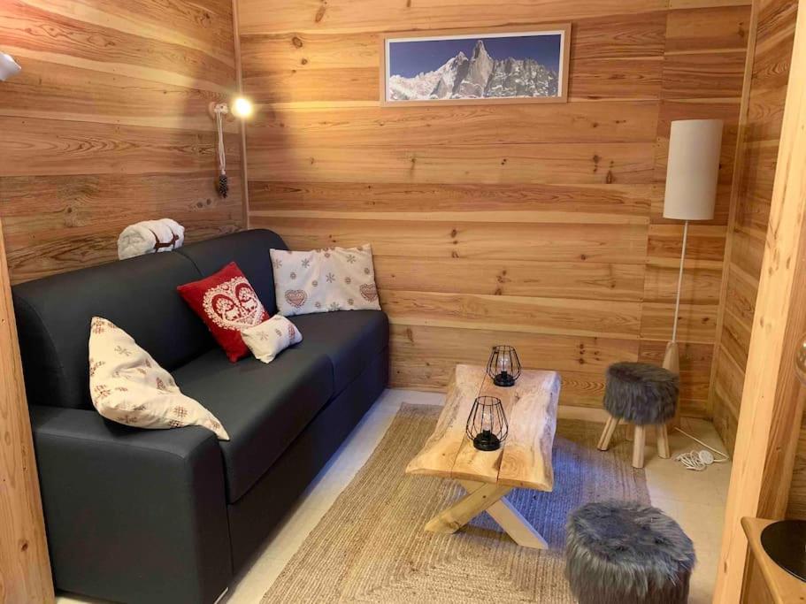 un salon avec un canapé noir et une table dans l'établissement Appartement cosy hyper-centre Cauterets, à Cauterets