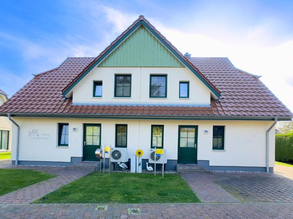una casa blanca con techo rojo en Schifferkaten, en Pruchten