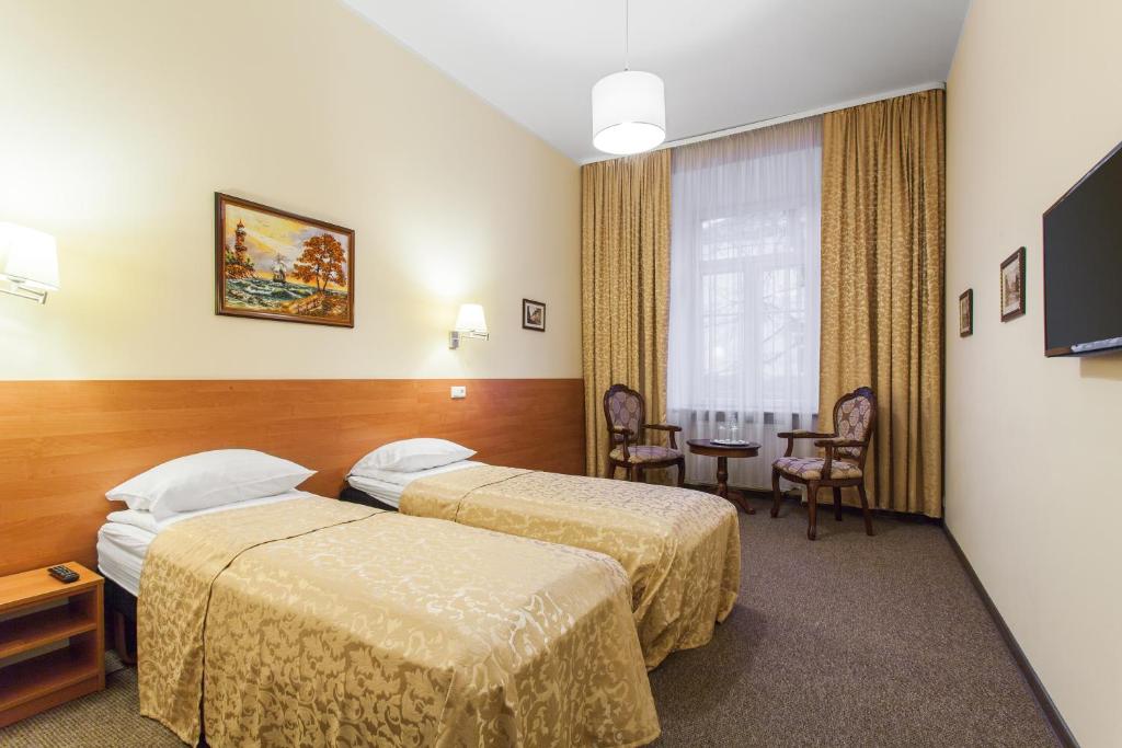 a hotel room with two beds and a table at Silvija House in Vilnius