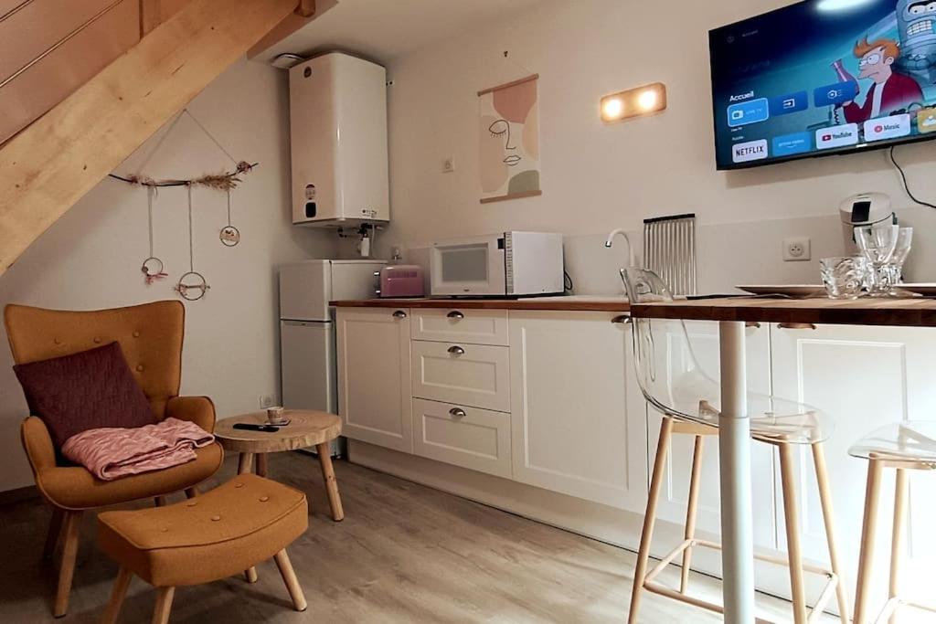 une cuisine avec un comptoir et une table avec une chaise dans l'établissement Le petit cocon, à Nevers