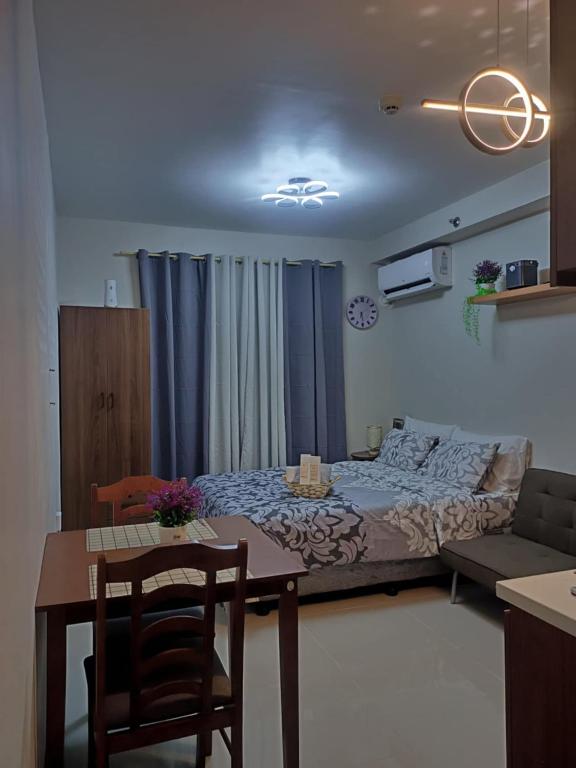 a bedroom with a bed and a table with chairs at Laugh tale Staycation in Suba