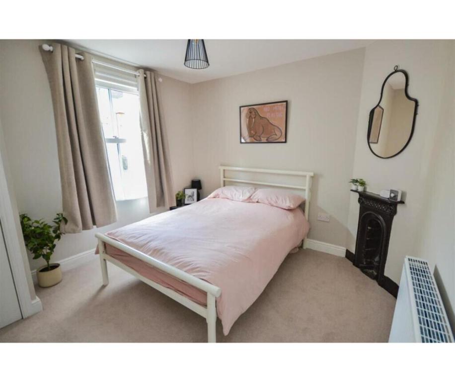 a bedroom with a bed with a fireplace and a window at Victorian Beach House in Saltburn By The Sea in Saltburn-by-the-Sea