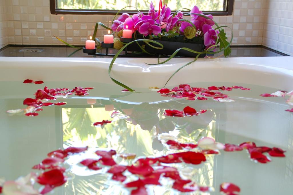 a bath tub with red flowers and candles on it at Full House Homestay in Yuchi