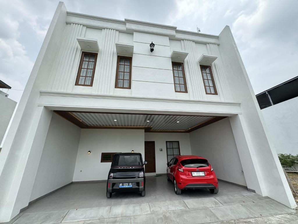a red car parked in front of a building at Griya Tegalweru Palagan Homestay Jogja in Ngaglik